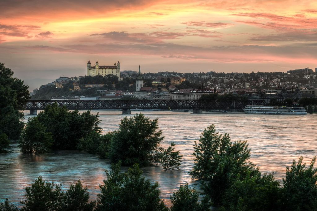 Bratislavský hrad a Dunaj s výletnou loďou pri západe slnka