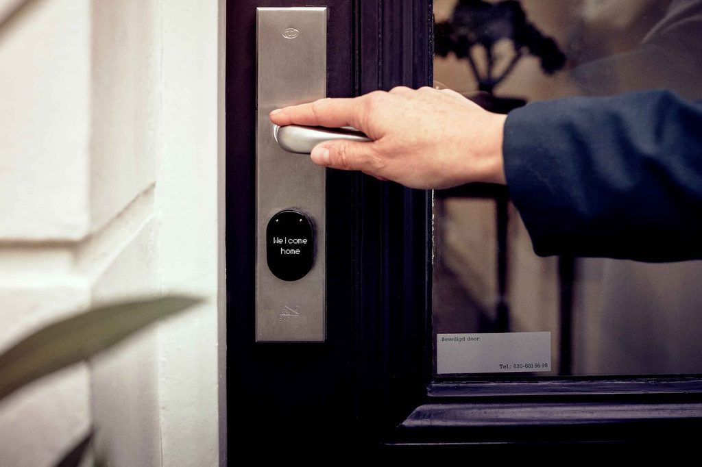 Ruka otvára dvere apartmánu cez smart zámok pri self check-ine